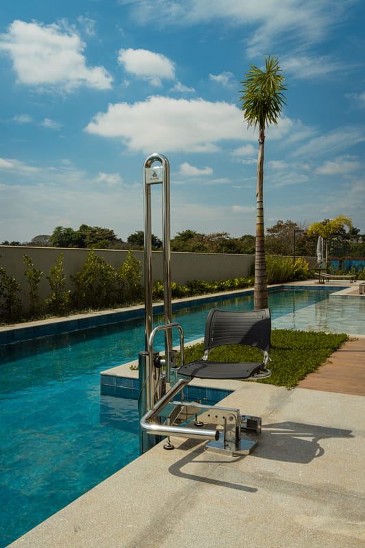 Piscina com acesso acessível e palmeira ao fundo